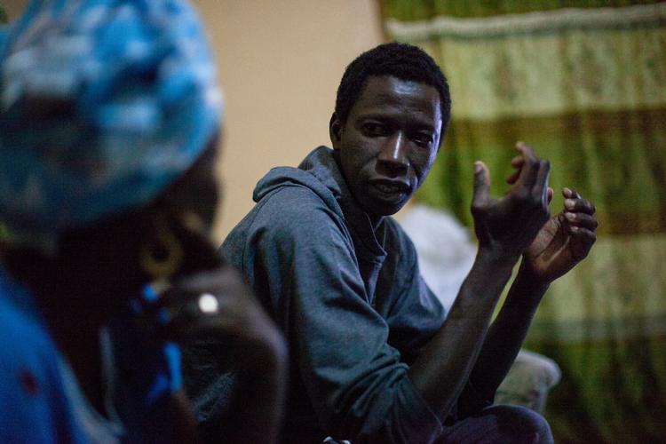 Abdoulie Manneh fortæller familien om den farefulde færd, da han bliver sendt hjem fra Libyen.  