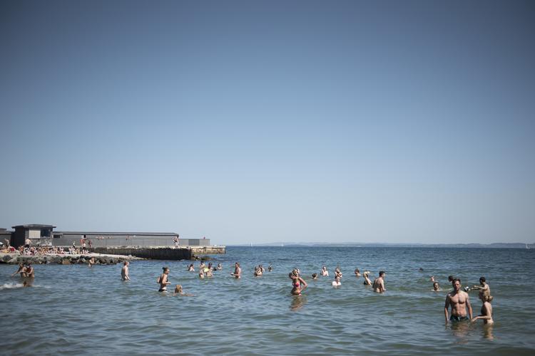 Aarhus. Den Permanente badet i solskin i maj måned, propfyldt af studerende, der holder ferie fra deres læseferie, pensionister, der strækker sig i solen og børnefamilier, der leger i vandkanten. Foto: Laura Krogh 
   Laura Bisgaard Krogh
