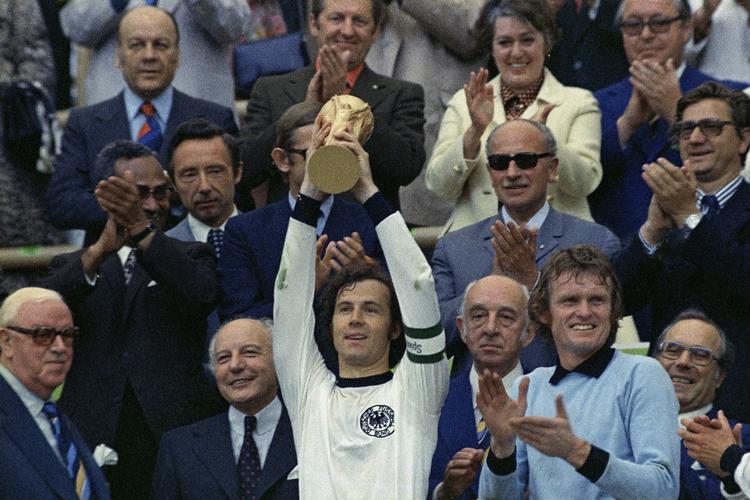 Franz Beckenbauer med VM-pokalen i 1974 efter finalesejren på 2-1 over Holland. Til højre er det målmanden Sepp Maier. /AP