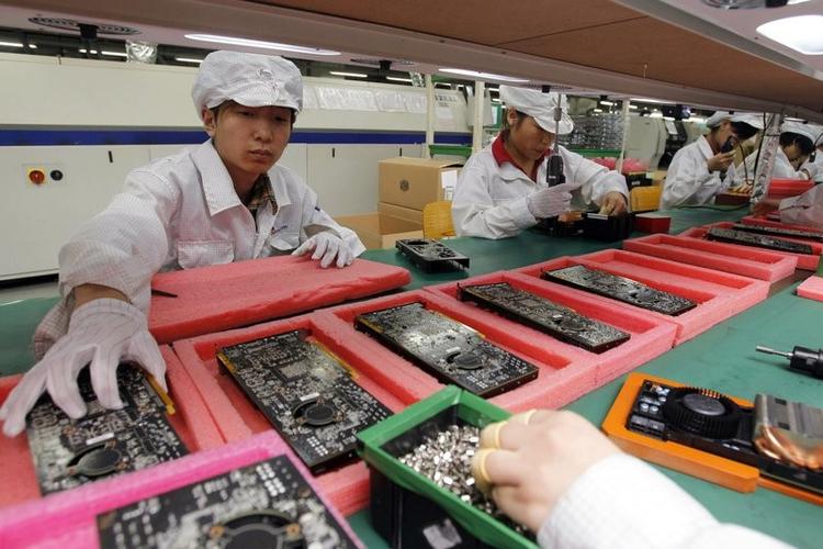 Fabriksarbejdere hos Foxconn, der producerer Kindle-læsere og Echo-højttalere for Amazon, men også iPhones for Apple og anden forbrugerelektronik for en række andre, store tech-firmaer (Foto: AP Photo/Kin Jeung). 