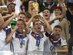 Lukas Podolski (tv.) anfører Philipp Lahm og Thomas Müller ser rimelig tilfredse ud med at have vundet VM. Noget sværere bliver det historisk set at genvinde pokalen. Martin Meissner/AP