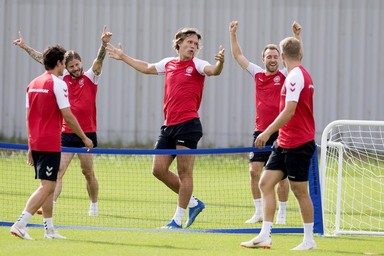 Humøret er højt i den danske VM-trup, hvor to af de tre med armene i vejret så godt som sikkert er i startopstillingen i dag: Lasse Schöne (t.v.) og Christian Eriksen (t.h.). Jannik Vestergaard sidder på bænken.  Finn Frandsen/POLFOTO