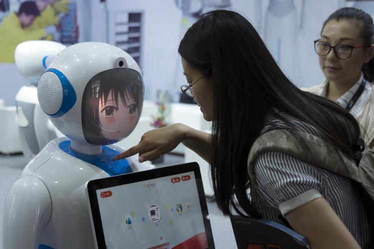 En kvinde ser på en kinesisk fremstillet robot på en teknologiudstilling i Shanghai i forrige uge. Netop robotteknologi ventes at få stor betydning for den globale økonomi i fremtiden. Sam Mcneil/AP