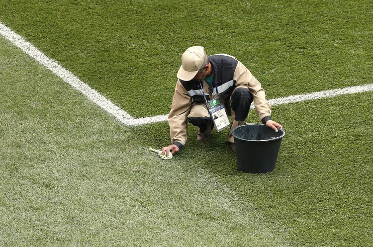 En stadiumarbejder forbereder banen til gruppekampen mellem England og Panama søndag ved VM i Rusland. Darko Bandic/AP