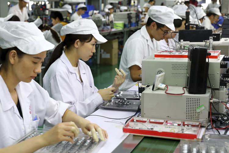 Kinesiske arbejdere på en fabrik i Huaibei laver indmad til telefoner. Kina er de seneste år blevet meget bedre til at producere banebrydende ny teknologi. Landet bruger dog stadig bøllemetoder og obstruktion over for udenlandske virksomheder. /AP