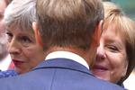 Theresa May og Angela Merkel fotograferet i et gruppekram med EU's præsident, Donald Tusk.  Geert Vanden Wijngaert/AP