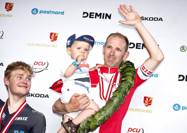 Frederik på knap to år stod den stormende jubelseance igennem uden at kny, da farmand Michael Mørkøv tronede øverst på podiet ved DM. Sølvvinderen Niklas Larsen ser smilende til.
   Nils Meilvang/Ritzau Scanpix