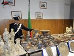 En italiensk betjent præsenterer nogle af de beslaglagte genstande. /AP