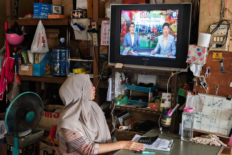 Araya Sinyang følger med i nyhederne i hendes købmandsbutik i byen Mae Sai, hvor de indspærrede drenge og deres fodboldtræner kommer fra. Claus Blok Thomsen