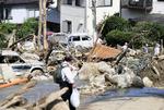Der kigges efter overlevende efter de voldsomme regnskyl blandt murbrokkerne i Hiroshima, Japan. Ryosuke Ozawa/AP