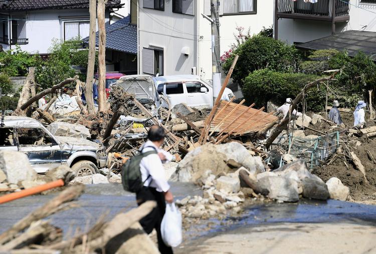 Der kigges efter overlevende efter de voldsomme regnskyl blandt murbrokkerne i Hiroshima, Japan. Ryosuke Ozawa/AP