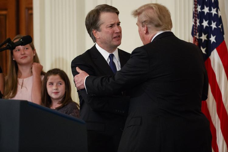 Præsident Donald Trump giver hånd før Brett Kavanaugh indtager scenen for at takke ja til nomineringen som højesteretsdommer. Evan Vucci/AP