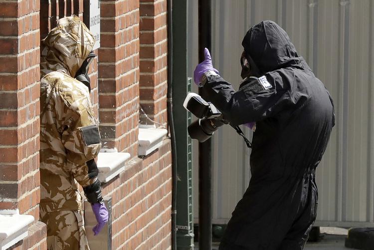 Britiske specialister er yderst forsigtige, når de skal undersøge steder i Amesbury for Novichok. Matt Dunham/AP