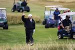 Trump tilbringer weekenden i sit Golf-resort i Skotland, men Putin har travlt med møder med besøgende ledere. Her vinker den amerikanske præsident til demonstranter.
   Peter Morrison/AP