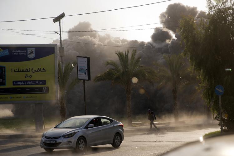 
    En palæstinensisk mand løber i skjul på grund af israelske luftangreb.
 Khalil Hamra/AP