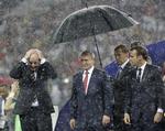 Mens Vladimir Putin hurtigt kom tørvejr, måtte Fifa-præsident Gianni Infantino (tv.) og franske Emmanuel Macron (th.) vente længe på en paraply, da regnen begyndte at stå ned i stænger over Moskva. 
   Matthias Schrader/AP
