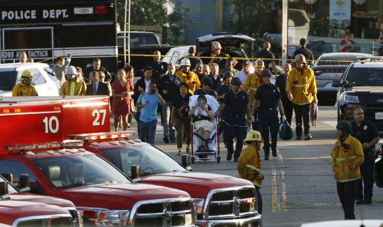 
   En såret kvinde bliver kørt til en ambulance efter gidselepisoden i Los Angeles. Damian Dovarganes/AP