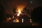 Brændende hus ved byen Mati. Thanassis Stavrakis/AP