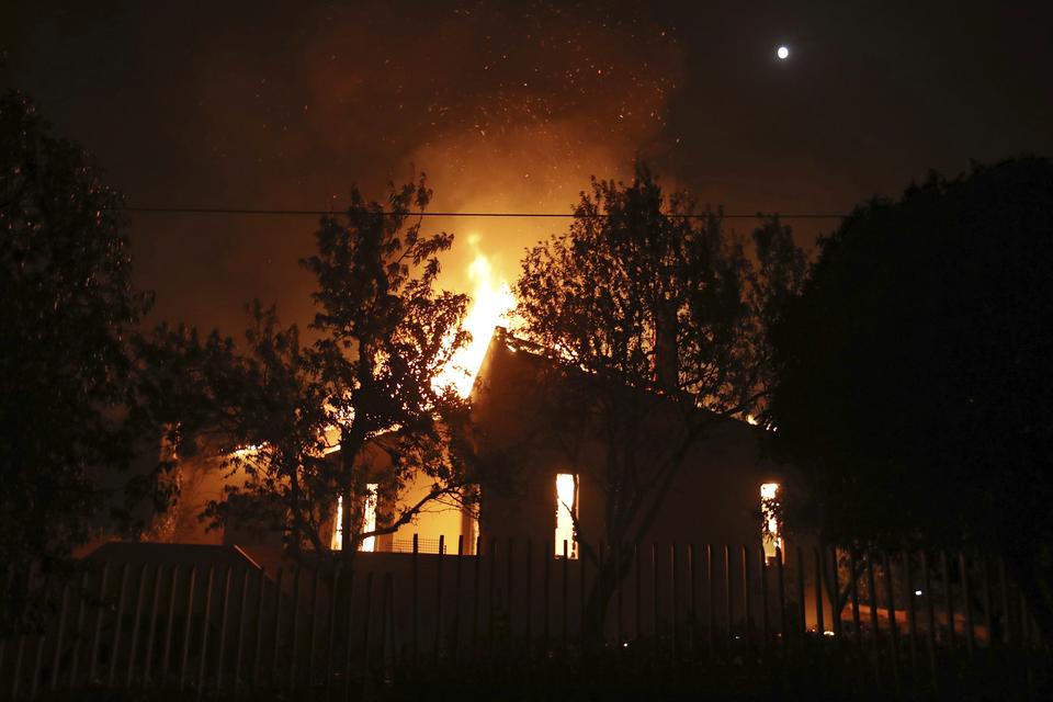 Brændende hus ved byen Mati. Thanassis Stavrakis/AP