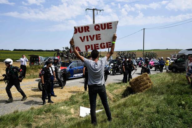 En demonstrant protesterer med skiltet "For en Piege-region, som man kan leve i". Lokale landmænd protesterede med halmballer mod vilkårene for det lokale landbrug. Foto: AFP/Jeff Pachoud.
   Jeff Pachoud/Ritzau Scanpix