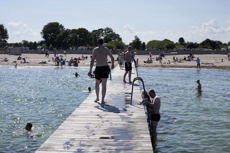 Solen har stort set ikke været blokeret af skyer og regn siden maj. Her køler folk sig af i vandet ved Amager Strand. Thomas Borberg/POLFOTO