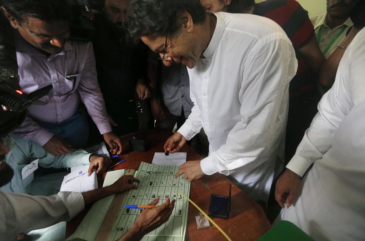  Imran Khan sætter her sin stemme på et valgsted i går. I dag udråber han sig selv som vinder. Anjum Naveed/AP