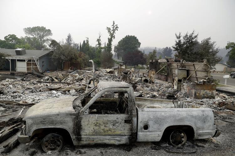 
    En efterladt og udbrændt bil foran et hjem raseret af en vild ildstom i går i Redding i det nordlige Californien.   Marcio Jose Sanchez/AP