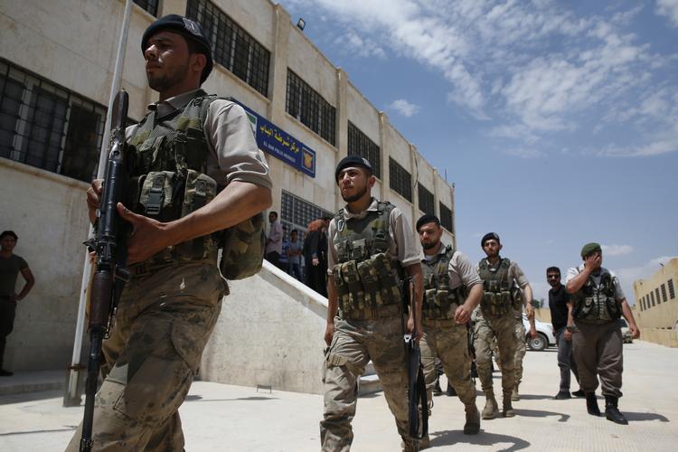 Soldater fra den syriske sikkerhedsstyrke marcherer foran politiets hovedkvarter i byen al-Bab i det nordlige Syrien. Arkivfoto. Lefteris Pitarakis/AP