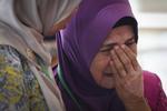 Sarah Nor, mor til Norliakmar Hamid - en af passagererne på det forsvundne MH370-fly, græder efter at have hørt det malaysiske undersøgelsesholds konklusioner. Vincent Thian/AP