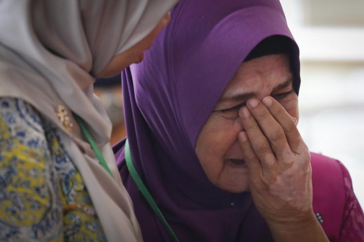Sarah Nor, mor til Norliakmar Hamid - en af passagererne på det forsvundne MH370-fly, græder efter at have hørt det malaysiske undersøgelsesholds konklusioner. Vincent Thian/AP