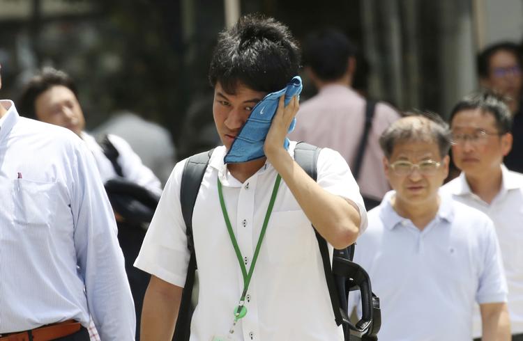 Med temperaturer over 40 grader blev der sat varmerekord i juli måned i Japan. Kort forinden var landet ramt af oversvømmelser. Koji Sasahara/AP