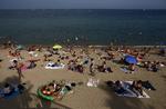 I Barcelona nyder mange strandgæster varmen. Andre har det nok sværere med de høje temperaturer. Manu Fernandez/AP