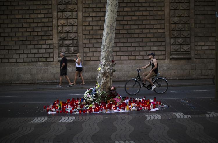 Stearinlys og blomster på Ramblaen i Barcelona minder om det angreb, hvor gerningmændene mejede 14 ofre ned og sårede yderliger 120 mennesker ved at pløje en varevogn gennem den menneskefyldte handelsgade. Emilio Morenatti/AP