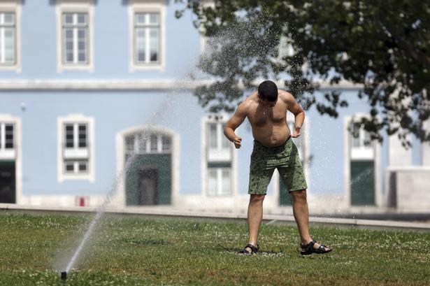 Et springkleranlæg i en park i Lissabon giver lidt afkøling. Armando Franca/AP