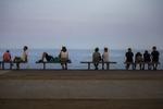 Varmen har drevet folk til kysterne som her, hvor bænkene er optaget langs Barcelonas strand. Emilio Morenatti/AP