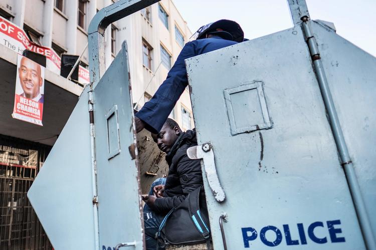 Politiet i Zimbabwe griber ind mod taberne af mandagens præsident- og parlamentsvalg. Torsdag - hvor dette billedet stammer fra - ransagede de oppositionens hovedkvarter.  Marco Longari/Ritzau Scanpix