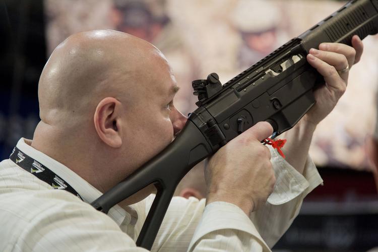 En konferencedeltager kigger gennem sigtekornet på en Sig Sauer semi-automatisk riffel i Las Vegas i 2013. Julie Jacobson/AP