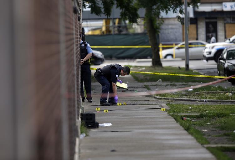 Politibetjente undersøger et gerningssted for endnu en skudepisode i Chicagos 'blodige weekend' søndag 5. august. Foto:  Joshua Lott/Getty Images/AFP   Joshua Lott/Ritzau Scanpix