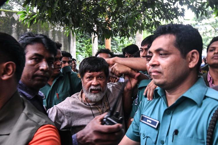 Shahidul Alam (med skæg) føres bort af politiet efter at have udtalt sig om situationen i Bangladesh på en ifølge myndighederne »provokerende måde«. Munir Uz Zaman/Ritzau Scanpix