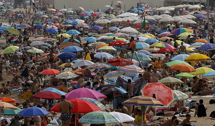 I Sydeuropa er der den seneste uge blevet målt ekstremt høje temperaturer pga. varme vinde fra Sahara. Her solbader spaniere på stranden i Barcelona. Manu Fernandez/AP