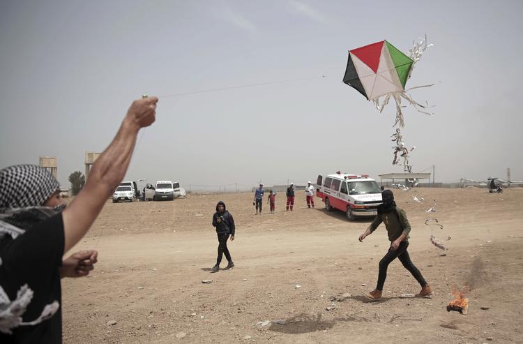 Militante palæstinensere sætter ild til klude under drager, som de sender ind over grænsen til Israel. Derefter skyder de dragerne ned for derved at antænde marker og tørre områder, når dragerne falder ned. Khalil Hamra/AP