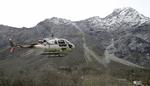 En helikopter letter fra fjeldet, Mannen. Eksperter frygter et stort stenskred, hvilket har fået myndighederne til at evakuere en del beboere.  Terje Pedersen/AP