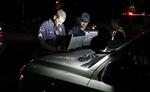Betjente fotograferet, mens myndighederne undersøgte, hvad der er sket.  Ted S. Warren/AP