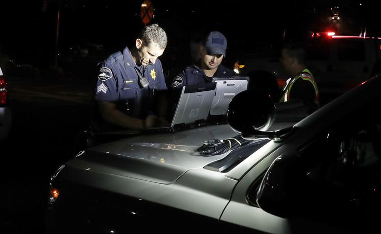 Betjente fotograferet, mens myndighederne undersøgte, hvad der er sket.  Ted S. Warren/AP