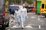 Retsmedicinere undersøger gerningsstedet i bydelen Moss Side i Manchester. Ti blev såret af skud.
    
   Peter Byrne/AP