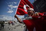 En gadesælger tilbyder tyrkiske flag til forbipasserende på gaden i storbyen Istanbul mandag, mens den tyrkiske centralbank forsøgte at bremse et markant fald i liraens kurs, som truer med at bringe hele Tyrkiets økonomi i knæ. (AP Photo/Lefteris Pitarakis)
   Lefteris Pitarakis/AP