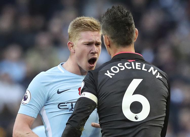 Kevin De Bruyne, der her raser over Arsenals Laurent Koscielny, må holde sig i ro det næste stykke tid, efter det onsdag gik galt ved træning.
   Martin Rickett/AP