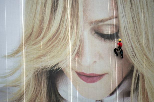 Hamborg, 2016. En arbejder hænger foran verdens største Madonna-plakat. Den fyldte 1.245 kvadratmeter, og var en del af hendes samarbejde med H&M.  Kai-uwe Knoth/AP