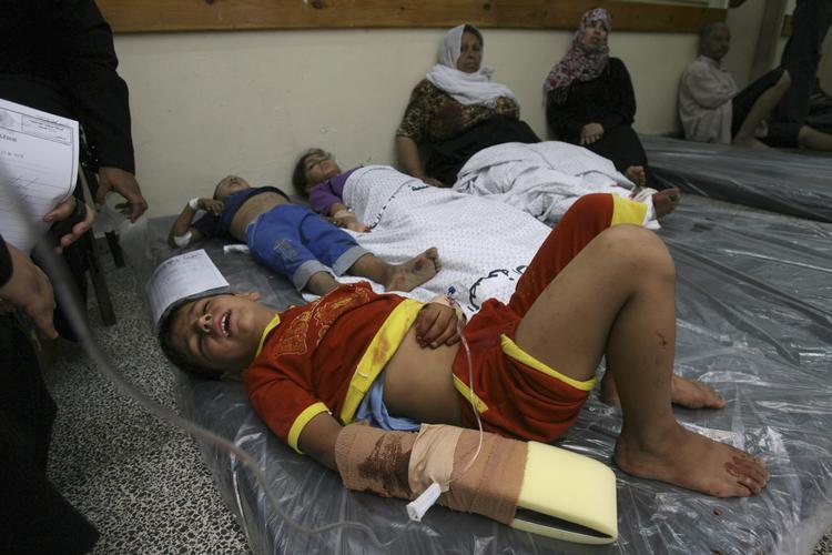 Sårede palæstinensiske børn ligger på madrasser spredt på gulvet på et hospital i Gaza efter et israelsk angreb 1. august 2014. Eyad Baba/AP