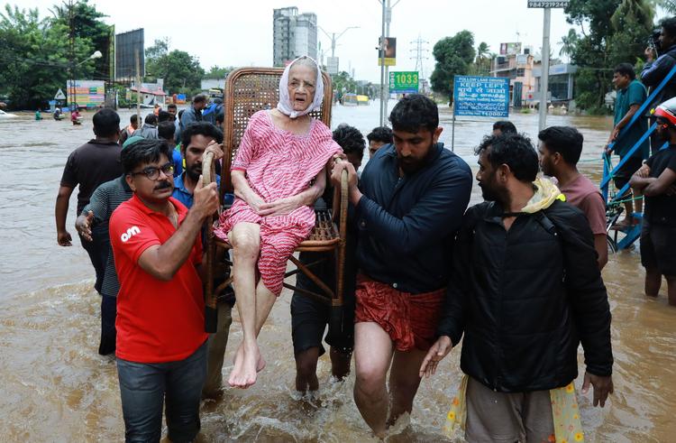 En kvinde evakueres fra en landsby i distriktet Ernakulam i Kerala. Over 220.000 har måttet forlade deres hjem, og over 300 mennesker har mistet livet i de alvorlige oversvømmelser. -/Ritzau Scanpix